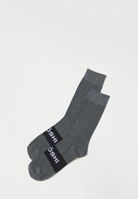 Calcetines gris oscuro hechos de una tela suave, con una banda negra y letras blancas cerca del puño; longitud hasta la mitad de la pantorrilla con una puntera sin costuras.