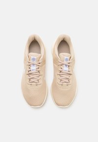 Zapatillas de running de malla beige con el logo de Nike en blanco, lazadas atadas y logo en la lengüeta, mostradas desde arriba sobre un fondo blanco.