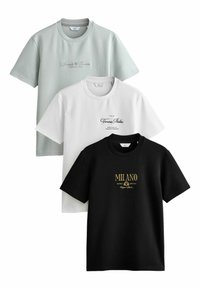 Tres camisetas en verde claro, blanca y negra. Cada una tiene un cuello redondo; la blanca y la negra presentan texto impreso en colores contrastantes.