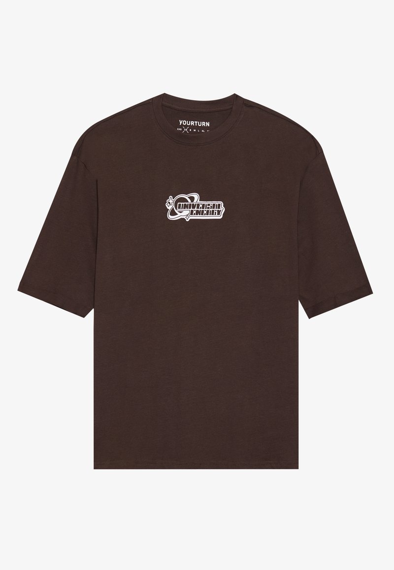 Camiseta de manga corta marrón hecha de algodón. Presenta un texto gráfico en blanco "Energía Universal" en la parte delantera. Diseño sencillo con cuello redondo.