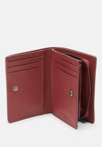 Red leather wallet with multiple card slots, a zippered compartment, and a snap button closure. Smooth texture and minimalist design.