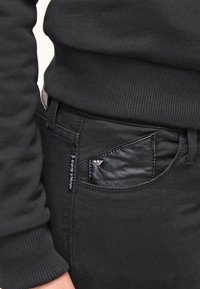 Svarta jeans med ett läderfickaccent, med en slim fit, subtil sömnad och en logotags på midjan.