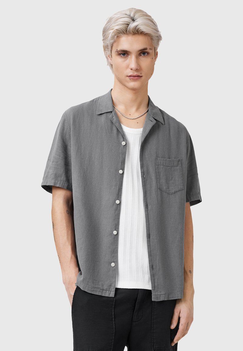Grijze kortekraag overhemd met knopen en een borstzak, gemaakt van lichtgewicht stof, gedragen over een wit gestructureerd shirt. Eenvoudig kraagontwerp.