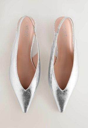 Srebrne metaliczne buty na odkrytej pięcie z wydłużonym czubkiem, ozdobione wycięciami i gładką fakturą. Wnętrze wyścielone jest różową podszewką.