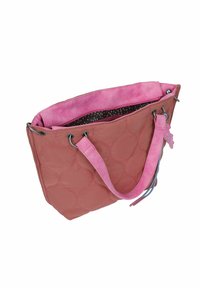 Gequilte tassentas in zachtroze stof met een contrasterende lichtroze binnenkant, voorzien van zilveren eyelets en decoratieve franjes.