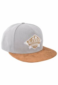 Gorra de béisbol gris con visera de ante marrón, que presenta un logo bordado en blanco y dorado en forma de diamante en la parte frontal.