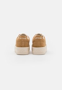 Zapatillas de corduroy marrón con un acabado texturizado, suela de goma beige y la marca "NO NAME" en la parte trasera y en los acentos laterales.