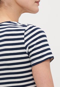 Navy and white striped t-shirt with short sleeves, featuring a round neckline and soft fabric, seen from the back.