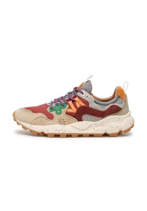 Sneaker sportiva multicolore con lacci viola, suola spessa screziata, pannelli beige e rossi e suola esterna marrone robusta, mostrata di profilo.