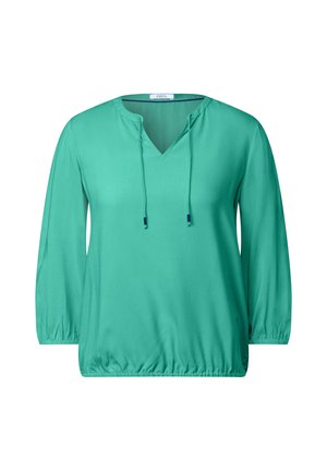 Blouse turquoise avec un décolleté en V et des cordons de serrage réglables. Possède des manches longues froncées et un ourlet fuselé pour une coupe décontractée.