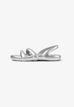 Infradito d'argento con una finitura liscia e opaca. Presenta tre cinturini ad anello e una suola sagomata per il comfort. Design minimalista.