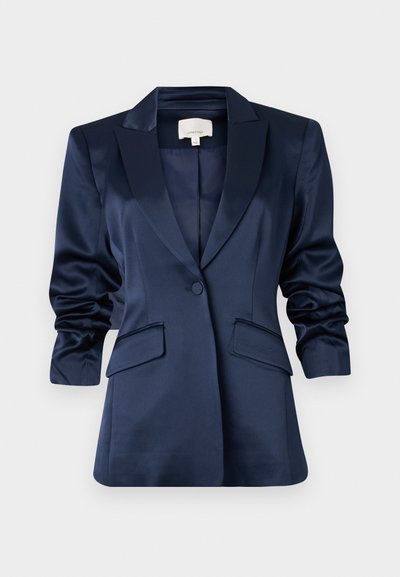 Námořnický saténový blazer se strukturovaným klopou, jedním knoflíkem, dvěma předními kapsami a mírně nařasenými rukávy. Hladká textura a přiléhavý střih.