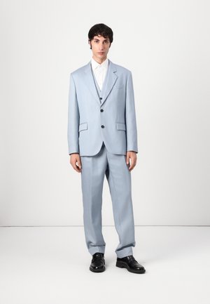 Light blue suit with a tailored jacket and matching trousers. Features black buttons, a single chest pocket, and a white shirt beneath.