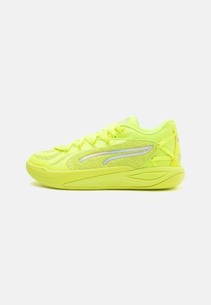 Baskets de sport vert lime avec une tige en mesh texturé, des accents réfléchissants et une semelle rembourrée, conçues pour la performance et le soutien.