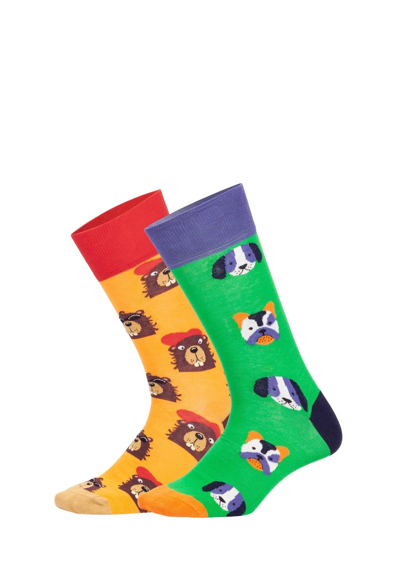 Dos calcetines coloridos: uno naranja con caras de oso que llevan sombreros rojos, y el otro verde con caras de perros de dibujos animados y puño púrpura.