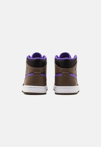 Sneakers w średnim zamknięciem z brązowej skóry z fioletowymi akcentami i białą podeszwą, z wyściełanym kołnierzem i teksturowanym piętą.