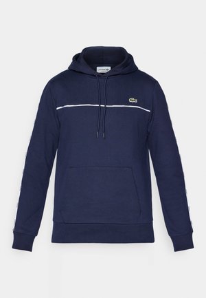 Navy blue hooded sweatshirt made of soft fabric. Features a kangaroo pocket, white stripe across the chest, and logo on the left side.
