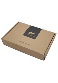 Scatola di cartone marrone con un'etichetta logo nera. L'etichetta presenta un orso stilizzato e il testo "slopes&town" con l'URL del sito web stampato sotto.