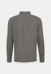 Grå rutiga långärmade skjortan med en knappad krage, med vita rutmönster och justerbara ärmslut. Bakifrån visas en yoke-design.