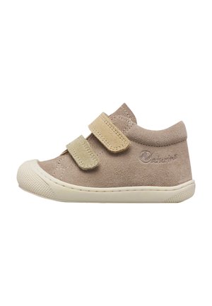 Scarpa beige per bambino piccolo con due cinturini in Velcro, materiale morbido in camoscio, suola in gomma e punta arrotondata, fotografata di lato su sfondo bianco.