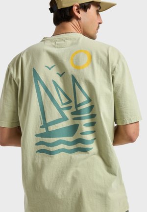 Hellgrünes Baumwoll-T-Shirt mit einem grafischen Design von drei Segelbooten, wellenförmigen Wasserlinien, zwei Vögeln und einer gelben Sonne.