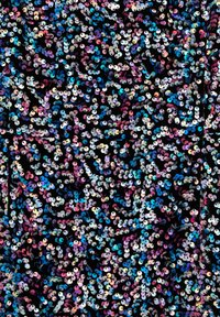 Sequins iridescents multicolores recouvrant densément un tissu noir, reflétant la lumière dans des tons bleus, violets, roses et argentés.