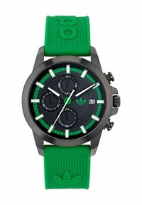 Svart analog klocka med gröna accenter och gummirem. Har tre underdials, datumvisning och ett texturerat grönt silikonband.