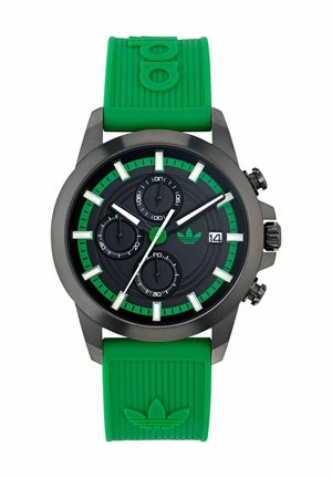 Montre analogique noire avec accents verts et bracelet en caoutchouc. Présente trois sous-cadrans, un affichage de la date, et un bracelet en silicone texturé vert.