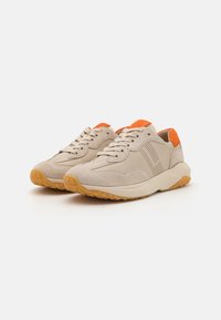 Beige mokkasiner i semsket skinn med oransje detaljer, perforerte elementer, solide snørebånd og en teksturert gummisåle med avrundet form.