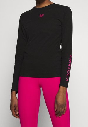 Camiseta negra de manga larga con corazón geométrico rosa en el pecho y texto rosa "PINK SODA" en la manga, combinada con leggings rosa brillante.