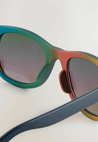 Färgglada solglasögon med en gradientram som övergår från teal till orange, med tonade linser, vadderad näsbrygga och eleganta svarta skalmar.