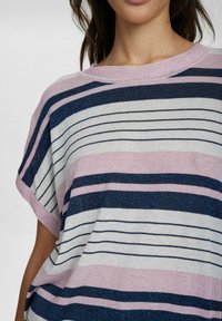 Svītrota blūze ar platiem rozā, tumši ziliem un baltiem bandiem. Adīta tekstūra ar brīvu piegriezumu un platiem piedurknēm. Apaļa kakla izgriezums.