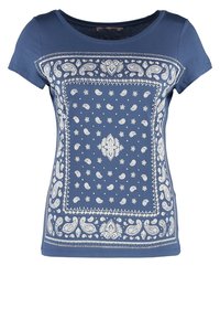 Blå bomullströja med korta ärmar, inredd med ett vitt paisleymönster och dekorativ kant. Rundad halsringning och vanlig passform.