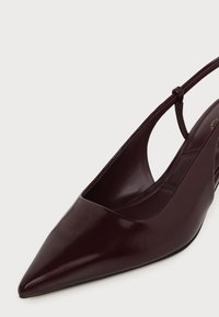 Chaussure slingback bordeaux foncé à bout pointu avec une finition en cuir lisse et une fine sangle autour du talon.