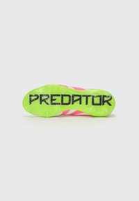 Football boots with a bright pink upper, white accents, and a textured green outsole featuring "PREDATOR" prominently displayed.