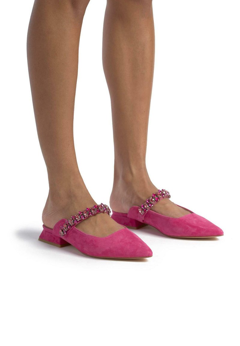 Mule in suede rosa con punta affusolata, caratterizzata da una fascia decorativa di gemme multicolori sul collo del piede. Tacco piatto, finitura testurizzata.