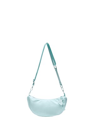 Sac à bandoulière bleu clair en forme de croissant avec une sangle réglable et une petite étiquette décorative sur le curseur de la fermeture éclair, isolé sur fond blanc.