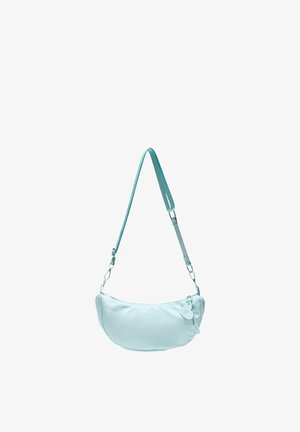 Sac à bandoulière bleu clair en forme de croissant avec une sangle réglable et une petite étiquette décorative sur le curseur de la fermeture éclair, isolé sur fond blanc.