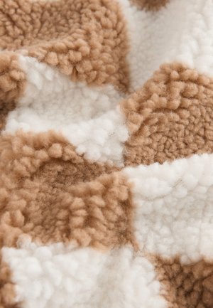 Hnedá a bielo kockovaná tkanina s chlpatým, textúrovaným povrchom. Vzorec obsahuje striedavé bloky mäkkého, plyšového materiálu.