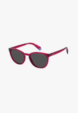 Rode doorzichtige cat-eye zonnebril met donkere glazen en paarse uiteinden op de frame-einden, met Polaroid-logo op de poten en glazen.