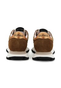 Baskets en daim marron avec des accents beiges, semelle intermédiaire blanche et semelle extérieure noire. Logo "SUN68" sur le détail métallique au niveau du talon, col rembourré.