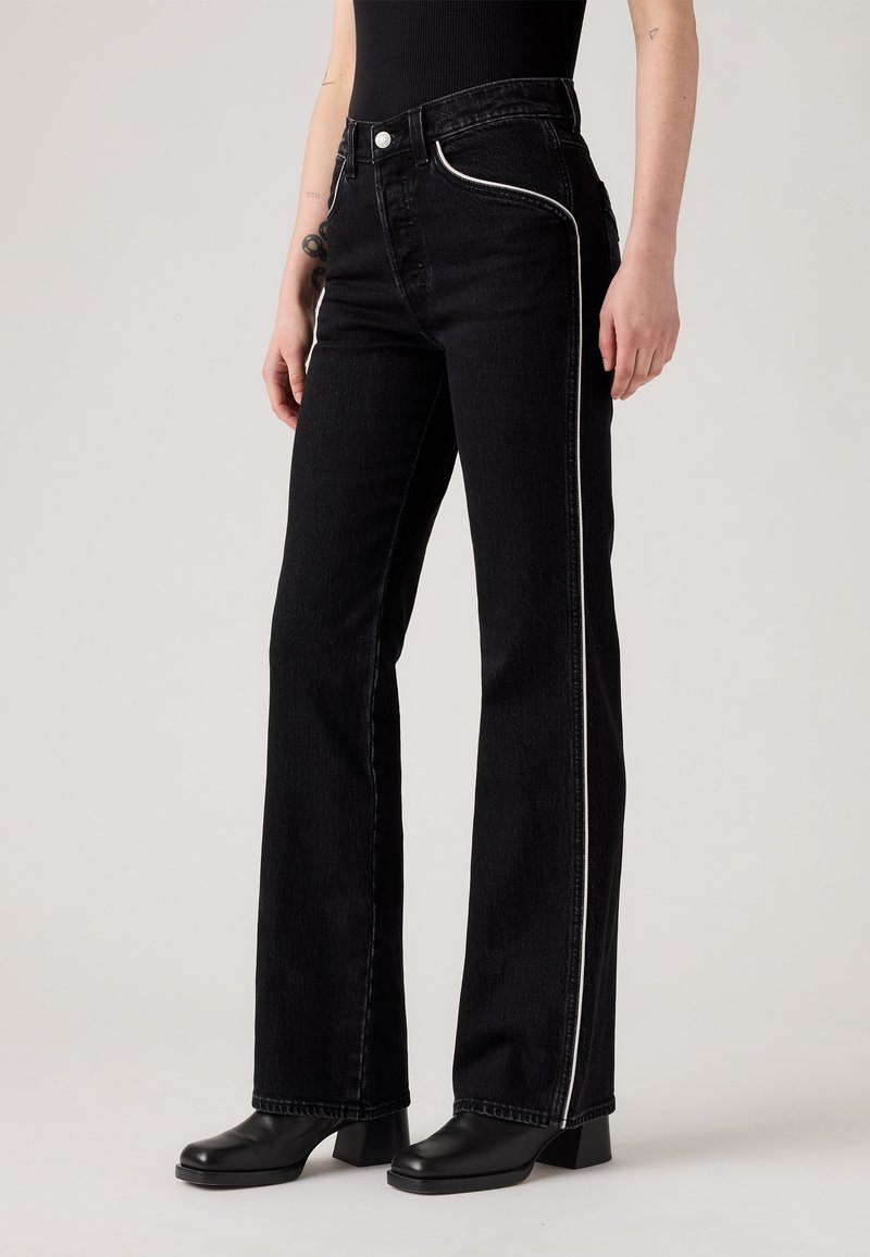 Zwarte denim jeans met een rechte pijp, voorzien van een witte bies langs de zijnaad en een klassieke knoopsluiting bij de taille.