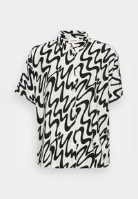 Košile s krátkým rukávem na knoflíky v bílé barvě s černým vlnitým vzorem, s límečkem a volným střihem. Vyrobena z lehké látky.
