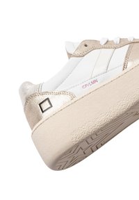 Hvide og metalliske guld sneakers med en tekstureret gummisål, der har en glat læderoverdel og en firkantet detalje på hælen.