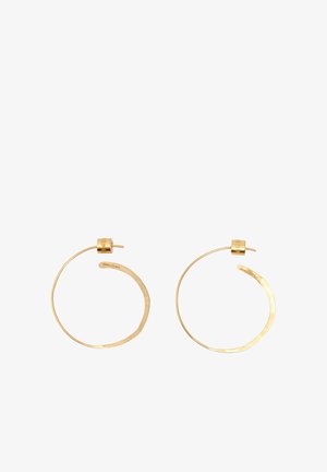 Par de pendientes de aro delgado e irregular de oro con cierre de poste, diseño minimalista y nombre de marca grabado sutilmente en el lado interior.