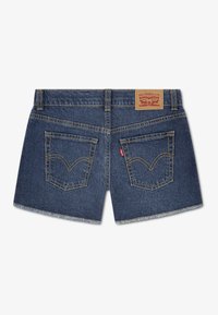 Σκούρα μπλε τζιν σορτς με ξέφτια στο τελείωμα, δύο πίσω τσέπες με κίτρινη ραφή και καφέ δερμάτινη ετικέτα στη μέση.