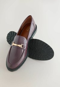 Paar kastanienbraune Loafers aus strukturiertem Leder mit schwarzen Gummisohlen und goldfarbenem Metall-Schnallen-Detail an der Vorderseite.