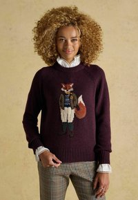 Bordeauxfarbener Pullover mit einem Fuchsdesign, der ein Blazer trägt, strukturierter Strick, gerippte Bündchen und ein weißer Rüschchenkragen darunter.