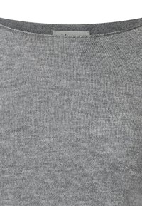 Grå stickad tröja med rund halsringning, mjuk textur och jämn vävstruktur. Etikett synlig på baksidan av nacken.