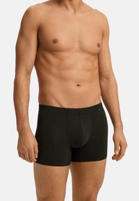 Černé boxerky vyrobené z měkké látky. Mají přiléhavý střih, elastický pás a decentní logo na boku.